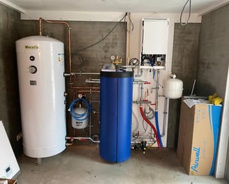 a room with a tankless water heater and a large blue tank