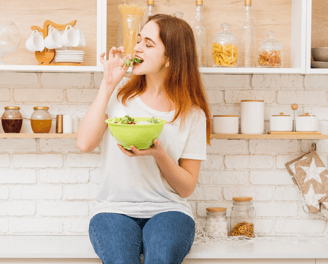 a woman sitting on a counter with a bowl of food