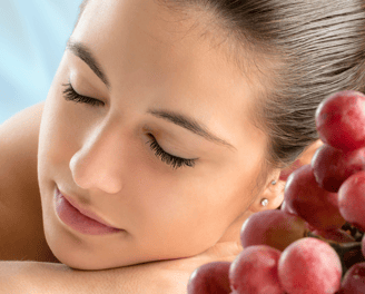 a woman with her hands on her chest and a bunch of grapes