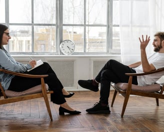 a man and woman sitting in chairs in a room