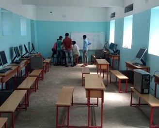 a classroom with desks and computers and desks