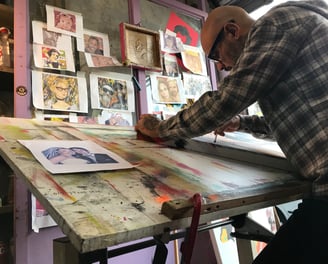 Sérgio Astral assinando uma pintura Pop-Art finalizada, dando seu toque final na obra.