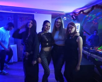 a group of people standing around a dj booth