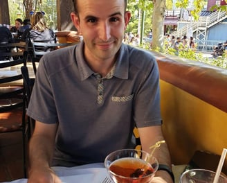 a man sitting at a table with a drink