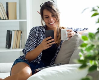 a woman sitting on a couch with a cup of coffee