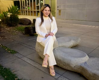 a female doctor in a whitecoat sitting in nature looking professional and friendly
