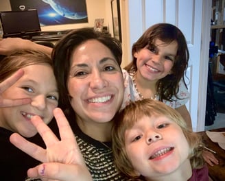 a woman with two children and a baby in a living room