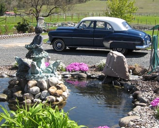 a car parked in a driveway with a statue of a bird on the side of