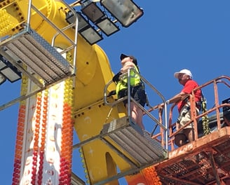 a woman inspector on a lifter at a carnival ride