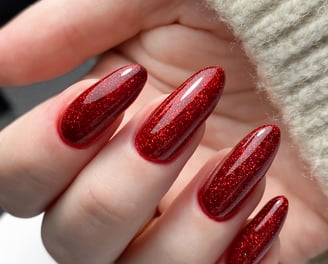 a person's hand holding a red manicured manicured manicure