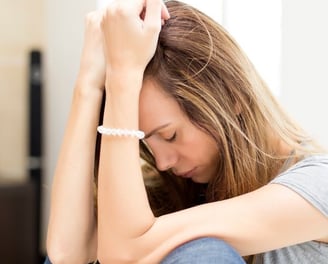 a woman sitting on a couch with a bracelet