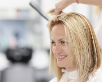 a woman is getting her hair cut by a hairdressuck