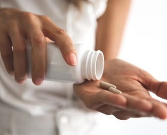 a woman holding a pill bottle