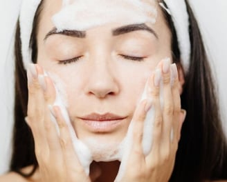 woman cleansing her face