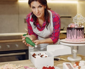 a woman in a apron is making cupcakes