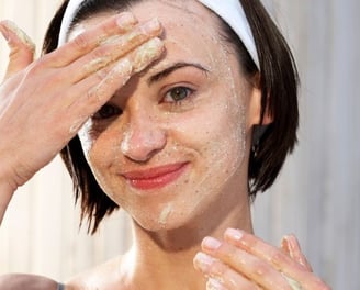 woman exfoliating her face