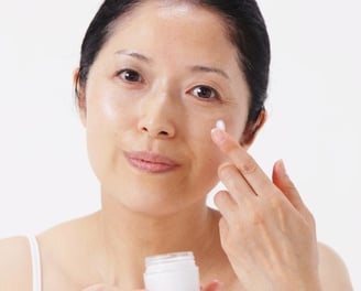 woman moisturizing her face