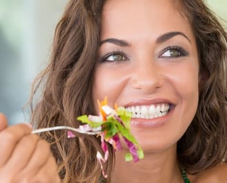 a woman eating a salad with a fork
