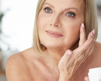 woman putting cream on her wrinkles