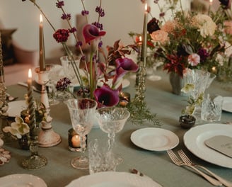 a table with a table setting with a candle and candles