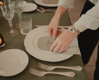 a person is setting a table with a plate of food