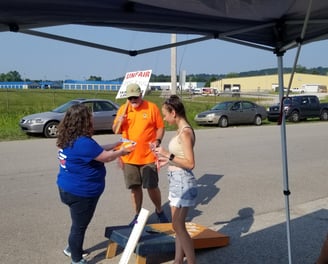 Woman in blue shirt speaking with two people on a picket line