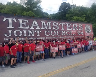 Large group in front of Teamsters truck with strike signs