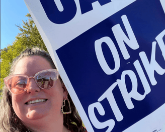 Woman in sunglasses holding strike sign