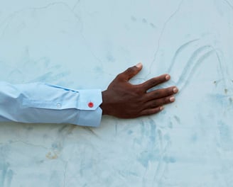 a person's hand holding a red button up