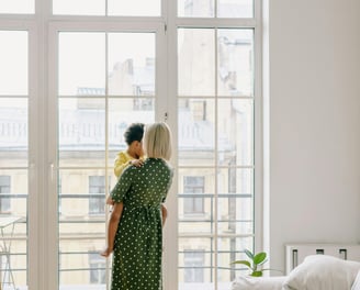 a woman in a green dress holding a baby