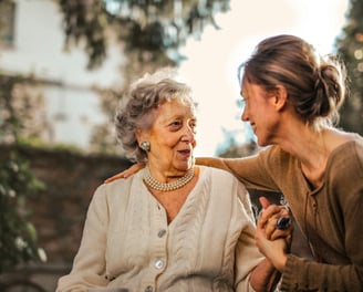 a woman in a brown sweater and pearls necklaces