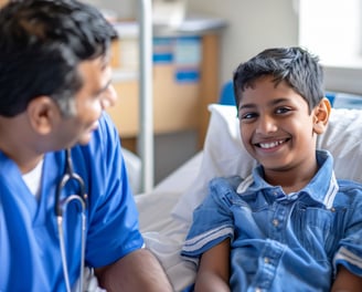 A doctor in blue scrubs is examining a young boy in a hospital bed.