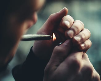 Persona encendiendo un cigarrillo, dispuesta a fumar