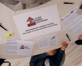 a group of people sitting around a table with AiS partnership papers
