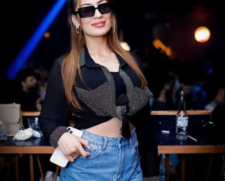 a woman in a black top and shorts with sunglasses