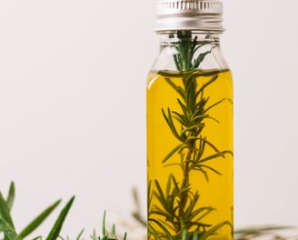a bottle of olive oil with rosemary sprigs kannauj pickupwale