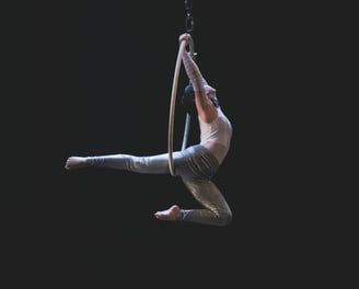 A man dancing on an aerial hoop
