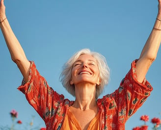 Mujer mayor levantando las manos hacia el sol y sonriendo 