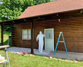 Professional Painter Spraying a Cabin Door for a Smooth, High-Quality Finish