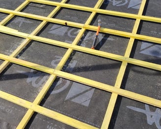 Installation de liteaux en bois sur un écran de sous-toiture lors de la rénovation d’une couverture à Audincourt, pour une me