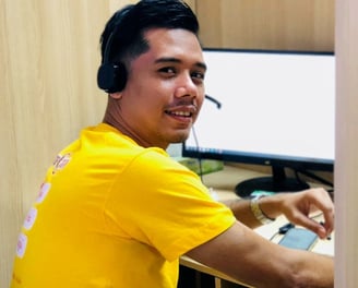 Dr Zaw wearing a headset looking back while working with a computer