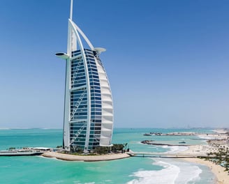 Dubai skyline with Burj Al Arab by the turquoise sea.
