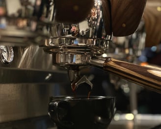 a cup of coffee being poured into a cup