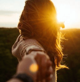 pareja en un campo agarrados de la mano felices despues de un amarre de amor efectivo