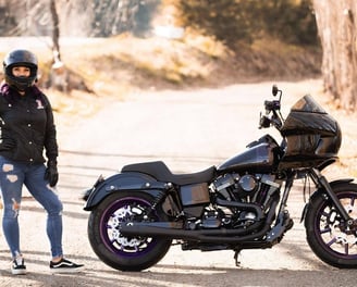 woman standing by black motorcycle