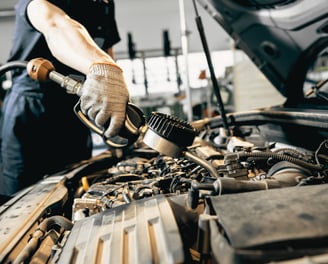 Mechanic adding fluids under the hood for optimal car performance