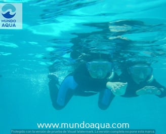 a boy and girl in scuba gear in the water