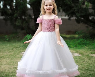 a little girl in a white dress with a pink princess bodice