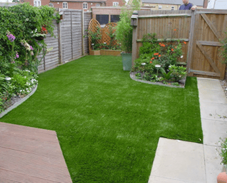 a backyard patio with a small garden and a wooden deck