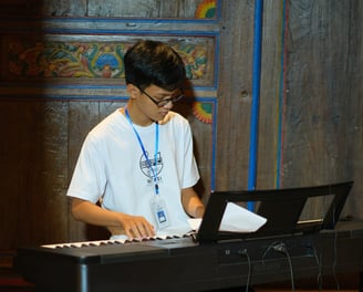 Tutor Kursus Musik Privat dari Notasi Music Course sedang Memainkan Piano